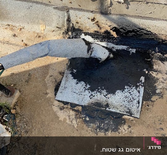 חומר איטום שחור על צינור ובסיס בטון